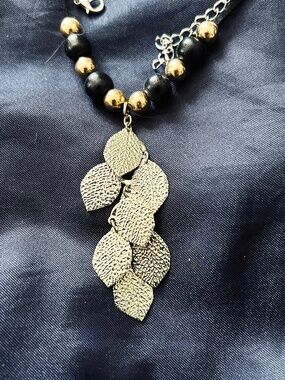 NECKLACE 7 SMALL TEXTURED METAL LEAVES WITH BLACK/GOLD BEADS ON SUEDE CORD,